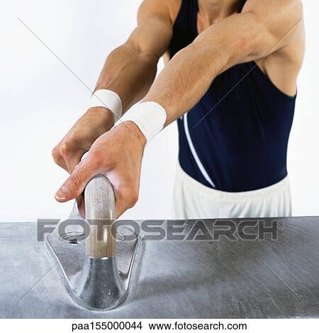 Male gymnast gripping handle on pommel horse, mid section. View Large Photo Image Picture - Male gymnast gripping handle on pommel horse, mid section.. Fotosearch