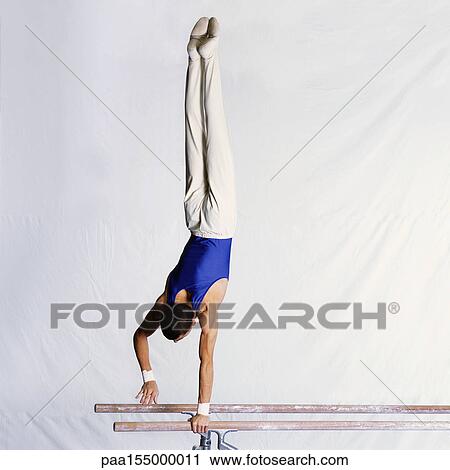 Male gymnast performing routine on parallel bars View Large Photo Image Stock Image - Male gymnast performing routine on parallel bars. Fotosearch