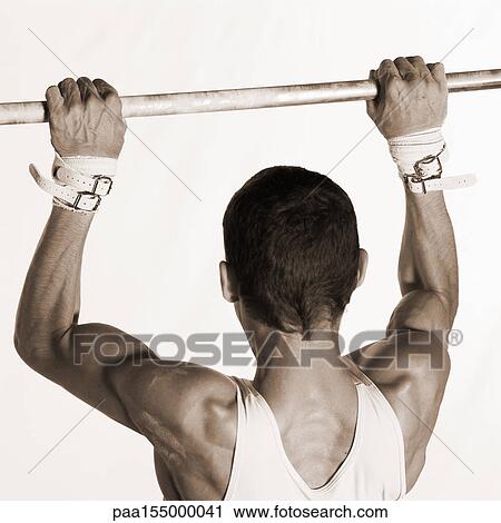 Male gymnast pulling himself up on horizontal bar, upper section, rear view, b&w. View Large Photo Image Stock Image - Male gymnast pulling himself up on horizontal bar, upper section, rear view, b&w.. Fotosearch