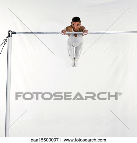 Male gymnast swinging on horizontal bar. View Large Photo Image Stock Image - Male gymnast swinging on horizontal bar.. Fotosearch