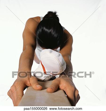 Stock Photograph - Young female gymnast in splits on balance beam.. Fotosearch
