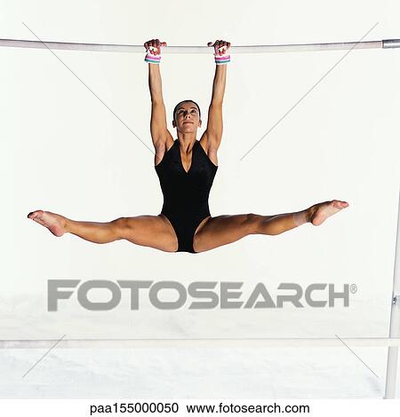 Young female swinging on uneven bars. View Large Photo Image Stock Image - Young female swinging on uneven bars.. Fotosearch