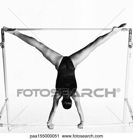 Young female upside down on uneven bars, rear view, b&w. View Large Photo Image Stock Image - Young female upside down on uneven bars, rear view, b&w.. Fotosearch