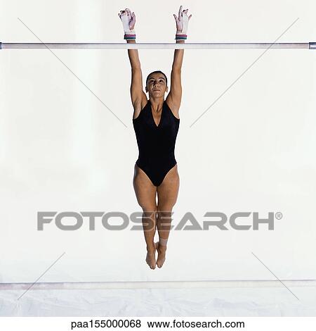 Young gymnast performing on uneven bars, mid-flight. View Large Photo Image Stock Photo - Young gymnast performing on uneven bars, mid-flight.. Fotosearch