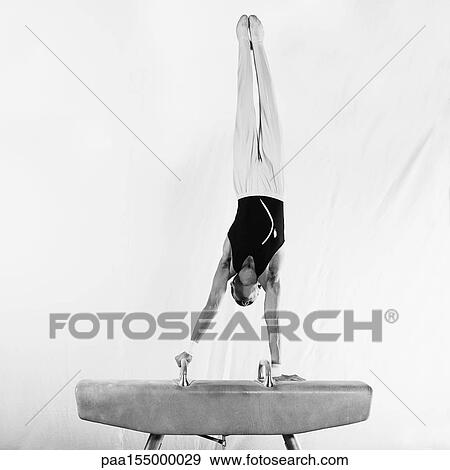 Young male gymnast in handstand on pommel horse, b&w. View Large Photo Image Stock Photo - Young male gymnast in handstand on pommel horse, b&w.. Fotosearch