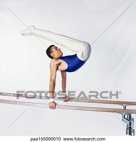 Young male gymnast on parallel bars, side view. View Large Photo Image Stock Image - Young male gymnast on parallel bars, side view.. Fotosearch