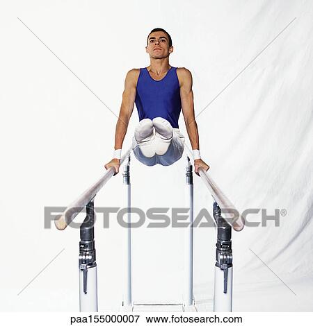 Stock Photo - Young male gymnast on parallel bars, front view.. Fotosearch