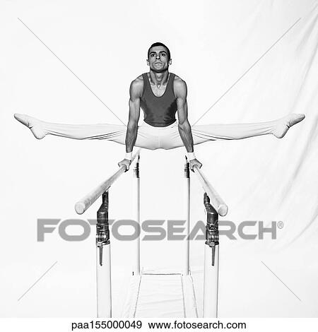 Young male gymnast on parallel bars, b&w. View Large Photo Image Stock Photo - Young male gymnast on parallel bars, b&w.. Fotosearch