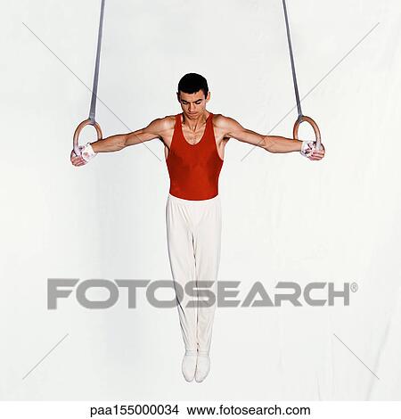 Young male gymnast performing routine on rings. View Large Photo Image Picture - Young male gymnast performing routine on rings.. Fotosearch