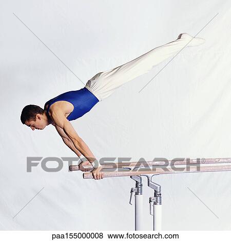 Young male gymnast performing routine on parallel bars. View Large Photo Image Stock Photo - Young male gymnast performing routine on parallel bars.. Fotosearch