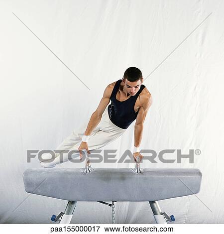 Young male gymnast performing routine on pommel horse. View Large Photo Image Stock Photo - Young male gymnast performing routine on pommel horse.. Fotosearch