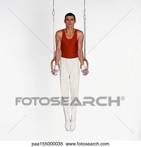 Young male gymnast performing routine on rings. View Large Photo Image Stock Photography - Young male gymnast performing routine on rings.. Fotosearch
