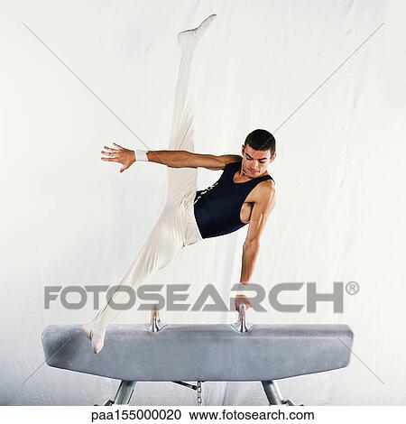 Young male gymnast performing scissors routine on pommel horse. View Large Photo Image Stock Image - Young male gymnast performing scissors routine on pommel horse.. Fotosearch