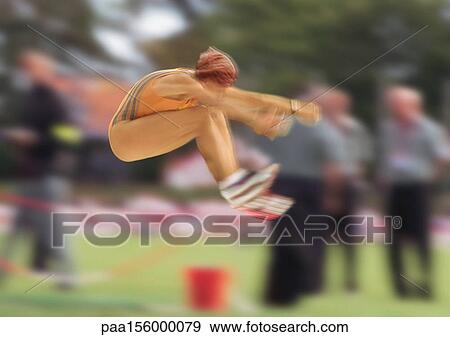 Female long jumper in mid-air, blurred motion View Large Photo Image Stock Photo - Female long jumper in mid-air, blurred motion. Fotosearch