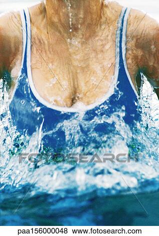 Stock Photo - Female swimmer emerging from water, close-up. Fotosearch