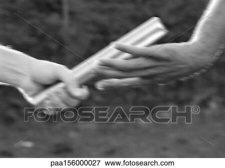 Male athletes passing relay baton, blurred motion, close-up, b&w View Large Photo Image Stock Photo - Male athletes passing relay baton, blurred motion, close-up, b&w. Fotosearch