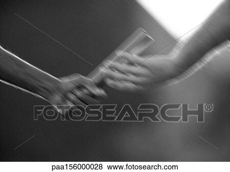 Male athletes passing relay baton, blurred motion, close-up, b&w View Large Photo Image Stock Photo - Male athletes passing relay baton, blurred motion, close-up, b&w. Fotosearch