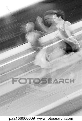 Stock Photo - Male athletes running fast, blurred motion, b&w. Fotosearch