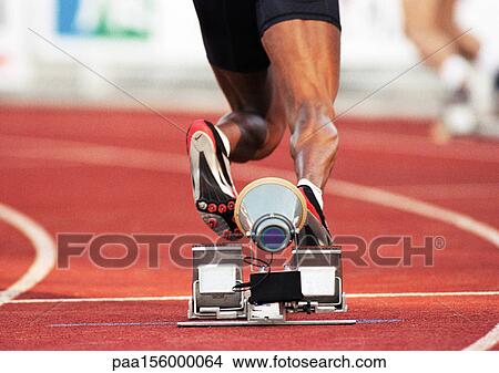 Picture - Male runner leaving starting block, low section. Fotosearch