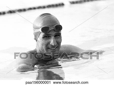 Stock Image - Male swimmer smiling in water, close-up, b&w. Fotosearch
