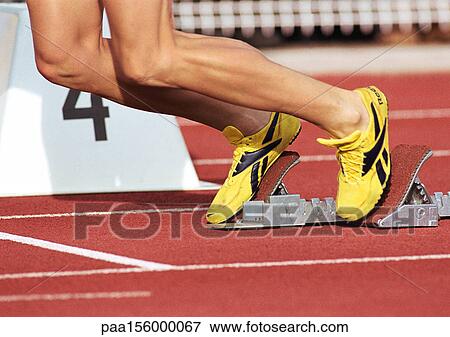 Runner leaving starting block, low section, close-up View Large Photo Image Stock Photo - Runner leaving starting block, low section, close-up. Fotosearch