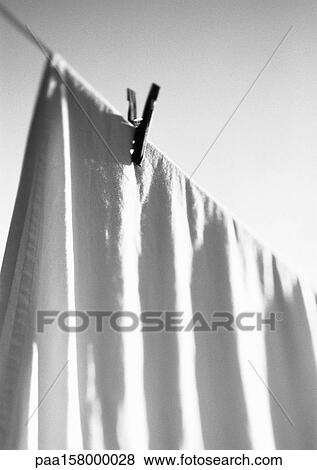 Stock Photo - Bed sheet hanging on line with clothes pin, b&w.. Fotosearch