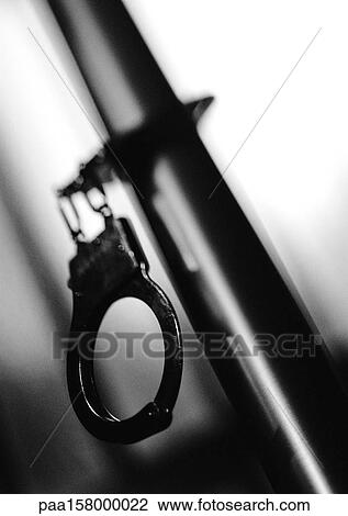 Handcuffs attached to pipe, b&w. View Large Photo Image Stock Image - Handcuffs attached to pipe, b&w.. Fotosearch