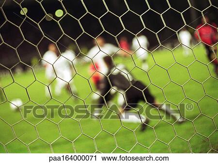 Goal keeper defending goal during a match, blurred, seen from behind net. View Large Photo Image Stock Image - Goal keeper defending goal during a match, blurred, seen from behind net.. Fotosearch