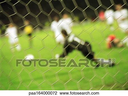 Goal keeper defending goal during a match, blurred, seen from behind net. View Large Photo Image Stock Image - Goal keeper defending goal during a match, blurred, seen from behind net.. Fotosearch
