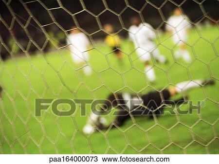 Goal keeper defending goal during a match, blurred, seen from behind net. View Large Photo Image Stock Image - Goal keeper defending goal during a match, blurred, seen from behind net.. Fotosearch