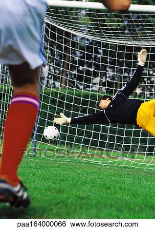 Goal keeper diving for ball during a match. View Large Photo Image Stock Photograph - Goal keeper diving for ball during a match.. Fotosearch