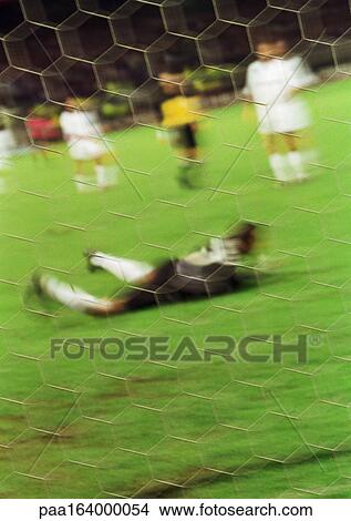 Goal keeper on ground in front of goal, blurred. View Large Photo Image Picture - Goal keeper on ground in front of goal, blurred.. Fotosearch