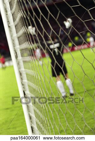 Goal keeper with arms up, rear view, blurred, seen from behind the net. View Large Photo Image Stock Image - Goal keeper with arms up, rear view, blurred, seen from behind the net.. Fotosearch
