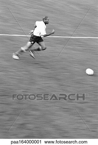 Man running after soccer ball, blurred, b&w. View Large Photo Image Stock Image - Man running after soccer ball, blurred, b&w.. Fotosearch