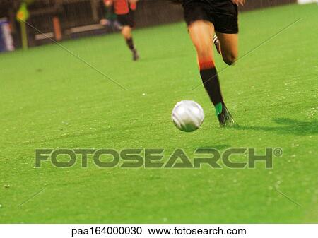 Player running for ball in soccer match, low section. View Large Photo Image Stock Image - Player running for ball in soccer match, low section.. Fotosearch
