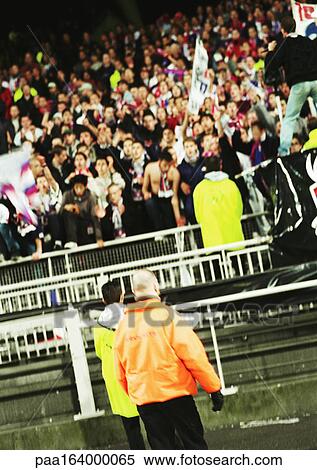 Stock Photography - Soccer fans during a match.. Fotosearch