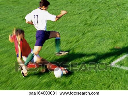 Soccer player reaching for ball, opponent jumping over leg, blurred. View Large Photo Image Stock Image - Soccer player reaching for ball, opponent jumping over leg, blurred.. Fotosearch