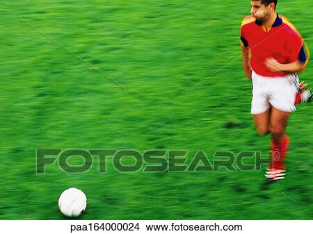 Soccer player running with ball, blurred View Large Photo Image Picture - Soccer player running with ball, blurred. Fotosearch