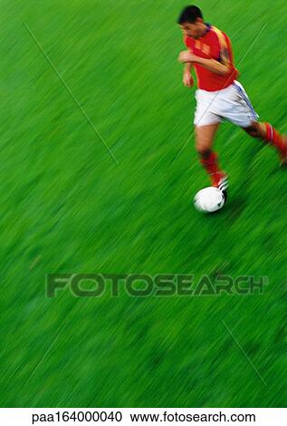 Soccer player running with ball, blurred View Large Photo Image Stock Image - Soccer player running with ball, blurred. Fotosearch