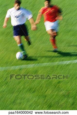 Soccer player running with ball, opponent chasing him, blurred View Large Photo Image Stock Image - Soccer player running with ball, opponent chasing him, blurred. Fotosearch