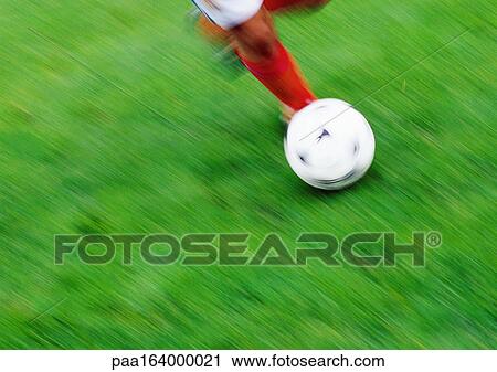 Soccer player's legs with ball, low section, blurred, grass in background View Large Photo Image Stock Image - Soccer player's legs with ball, low section, blurred, grass in background. Fotosearch