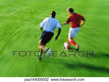 Two soccer players running for ball, blurred View Large Photo Image Stock Image - Two soccer players running for ball, blurred. Fotosearch