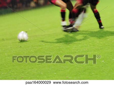 Two soccer players running for ball, blurred, low section. View Large Photo Image Stock Photo - Two soccer players running for ball, blurred, low section.. Fotosearch