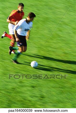 Two soccer players running for ball, blurred View Large Photo Image Stock Photo - Two soccer players running for ball, blurred. Fotosearch