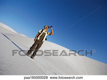 Hiker standing on dune, drinking. View Large Photo Image Stock Photo - Hiker standing on dune, drinking.. Fotosearch