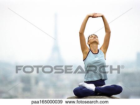 Paris, France, woman sitting with legs crossed and arms stretching up, Eiffel tower in background View Large Photo Image Stock Photo - Paris, France, woman sitting with legs crossed and arms stretching up, Eiffel tower in background. Fotosearch