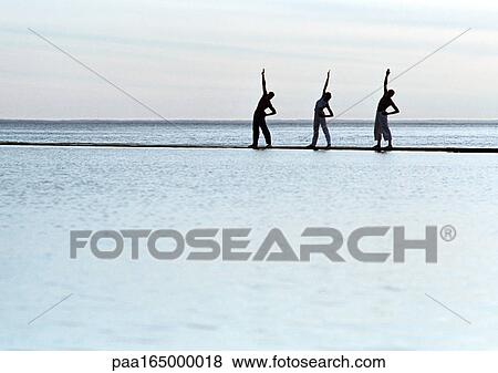 Stock Photo - Three people exercising by the sea.. Fotosearch