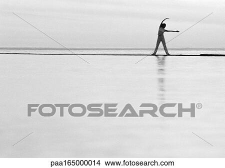 Woman exercising by the sea, b&w. View Large Photo Image Picture - Woman exercising by the sea, b&w.. Fotosearch