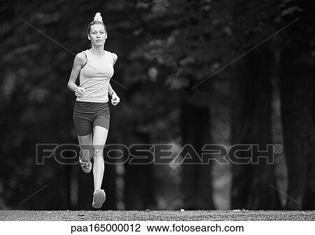 Woman running, full length, trees in background, b&w View Large Photo Image Stock Image - Woman running, full length, trees in background, b&w. Fotosearch