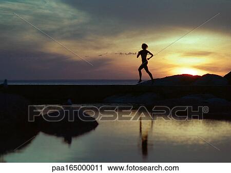 Woman running near water at sunset, silhouette View Large Photo Image Stock Image - Woman running near water at sunset, silhouette. Fotosearch